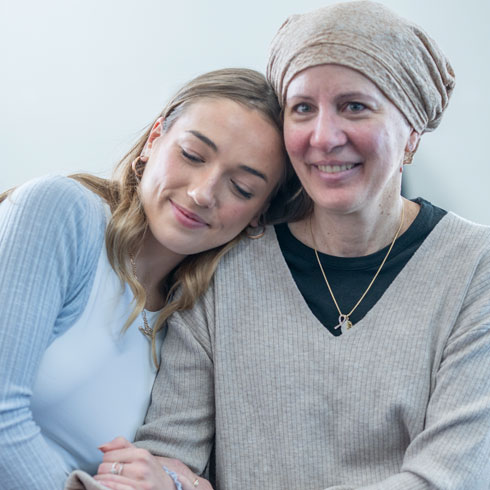 Senior woman with cancer sitting next to daughter