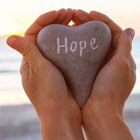 Rock with the word Hope on it being held in hands