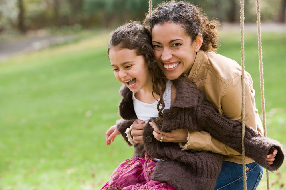 Mom and daughter riding on a swing