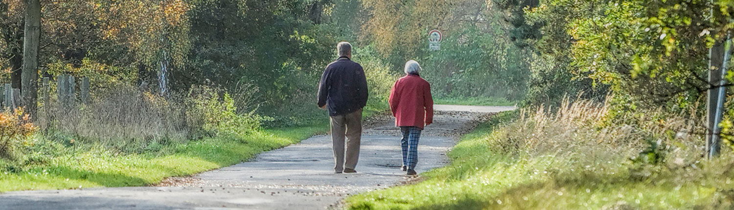 Senior Couple walking on trail away from camera