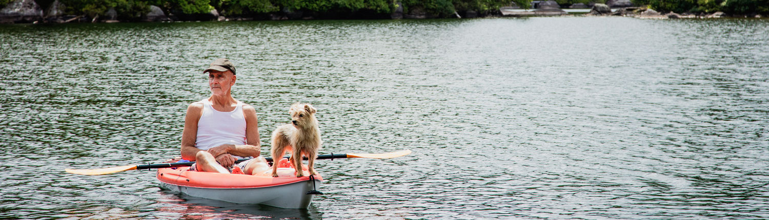 Senior man and his dog in a canoe