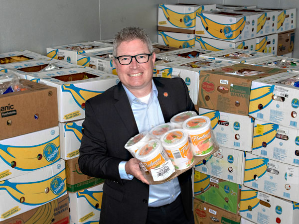 Joe Ayer holding food in a food bank